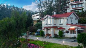 a white house with a red roof at The Humming Bird A Stay Chapter in Ooty