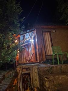 a green chair sitting outside of a house at night at Hideaway holt in Banjār