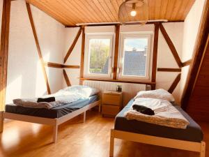 due letti in una stanza con due finestre di Odw homes - charmantes Domizil im Gorxheimertal a Kunzenbach