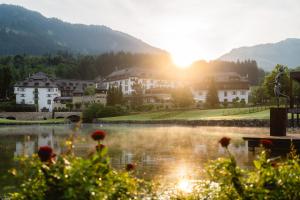 una vista di un resort con un lago e degli edifici di Schlosshotel Kitzbühel A-ROSA Collection a Kitzbühel