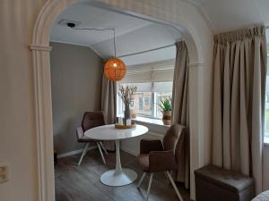 a dining room with a table and chairs and a window at Bed & Breakfast In de oude bakkerij in Nieuwdorp
