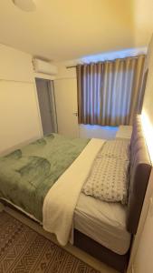 a bedroom with a large bed with a window at Apto completo, Piscina, Cinema, Home Clube e Jardim in Piçarras +22 photos