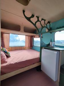 Les Moitiers-dʼAllonneCamping Les Ronds Duval face aux îles anglo-normandes的小房间,墙上有一棵树,还有一张床