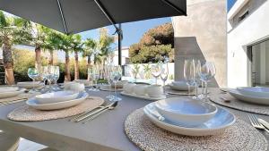 a table with plates and wine glasses on it at La Maison de La Plage in Le Grau-dʼAgde