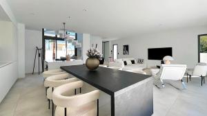 a kitchen and living room with a table and chairs at La Maison de La Plage in Le Grau-dʼAgde