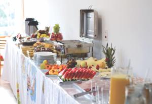 a buffet line with fruits and plates of food at Hotel Dorta's in Monte Sião