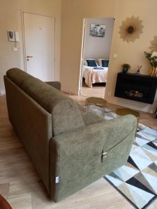 un salon avec un canapé et une cheminée dans l'établissement Appartement centre médiéval le Boudoir de Marie, à Sarlat-la-Canéda