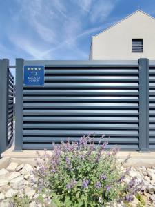 a fence with a blue sign on the side of a building at Villa Zvonimir in Sreser
