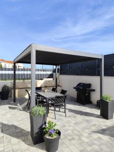 a patio with a tent and a table and a grill at Villa Zvonimir in Sreser