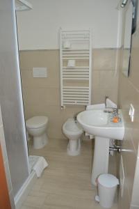 uma casa de banho com um lavatório e um WC em Camere I Monelli em Assis