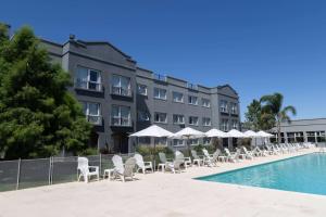 a hotel with chairs and umbrellas next to a swimming pool at Howard Johnson by Wyndham Funes in Funes