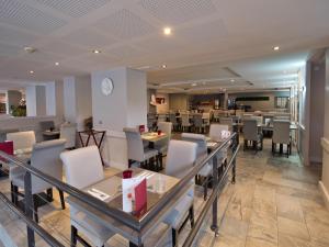 a dining room with tables and chairs in a restaurant at La Table de Gustave Hôtel Restaurant Espace Bien-Être in Ornans