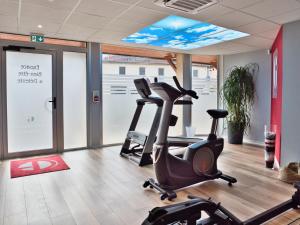 a gym with two exercise bikes in a room at La Table de Gustave Hôtel Restaurant Espace Bien-Être in Ornans