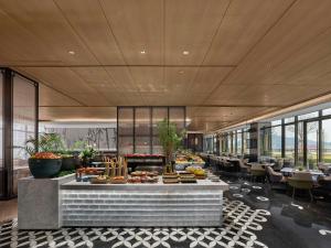 a buffet line in a restaurant with tables and chairs at Hilton Yuyao in Yuyao
