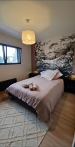 a bedroom with a large bed with a pendant light at Cocon familial proche des plages 10 personnes in Quimper