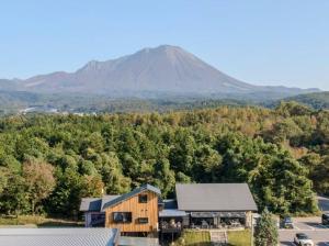 uma montanha à distância com um edifício em primeiro plano em Jimmy Kuu em Yonago