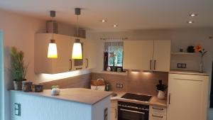 a kitchen with white cabinets and a counter top at Spreewaldferienhaus Kupa in Burg +10 photos