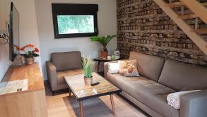 a living room with a couch and a brick wall at Spreewaldferienhaus Kupa in Burg