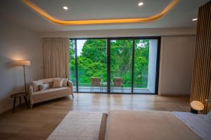 een woonkamer met een bank en een groot raam bij Brand new 3 bedrooms villa in Ko Samui +60 foto's