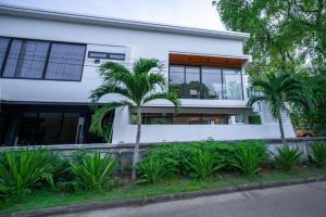een wit huis met palmbomen ervoor bij Brand new 3 bedrooms villa in Ko Samui