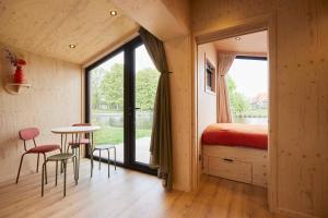 a room with a bed and a table and chairs at Tetris Tiny House in Den Bosch