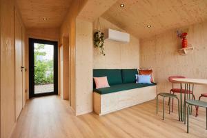 a room with a green bench and a table at Tetris Tiny House in Den Bosch