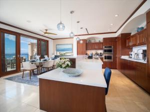 une cuisine avec des placards en bois et une salle à manger dans l'établissement Welcome To Our Beautifully Remodeled & Redecorated Sea La Vie L510 At Wailea Beach Villas!, à Wailea