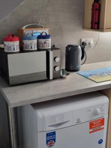 a microwave sitting on a counter next to a dishwasher at 2 Beach House in Bridlington