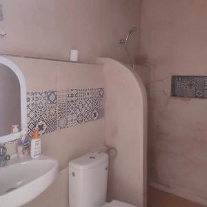 a bathroom with a white toilet and a sink at Darna 4 in Demina