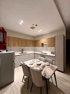 a kitchen with a table and chairs and a refrigerator at Lovely Apartment-A and B with Two bedrooms in Al Khobar