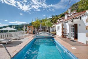 a villa with a swimming pool and a house at El Estanco 14 in Vega de San Mateo