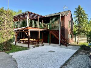 a building with a deck and a table and benches at Bamboo Rooms - Studios in Štúrovo