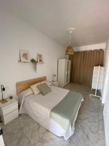 a bedroom with a large bed and a refrigerator at Casa El Rincón de San Pedro in Arcos de la Frontera