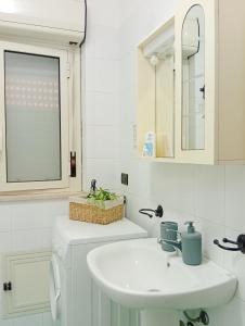 a white bathroom with a sink and a mirror at Finestra sul Mare di Alessandro in Balestrate +68 photos