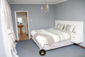 a bedroom with a large bed and a chandelier at KSG GuestFarm in Eikenhof