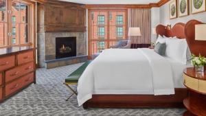 une chambre avec un grand lit blanc et une cheminée dans l'établissement Aspen St Regis Residence Club 3 Bedroom, à Aspen 19 autres photos