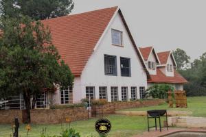a large white house with a red roof at KSG GuestFarm in Eikenhof