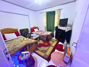 a room with two beds and a television in it at Gadou Rooms -Private & Shared Stays in Port Said Best Location in Port Said