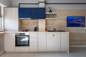 a kitchen with white cabinets and a sink at Rezidential Park Letea by Rooms in Bacău