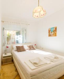 a bedroom with a large white bed with a window at Dubrovnik center apartment in Dubrovnik