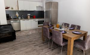 a kitchen with a wooden table with chairs and a stove at simply-una in Bihać