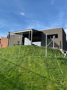 a building on top of a grassy hill at Relais Dulce Vitae in Porza