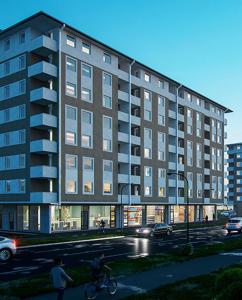 Un gran edificio en una calle con una persona montando en bicicleta. en Hedonist Garden Luxury Apartments, en Doboj