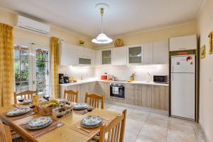 a kitchen with a wooden table and a dining room at Pasiphae Holiday Apartments in Kontokali +36 photos