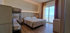 Postel nebo postele na pokoji v ubytování Hotel Kursaal - FRONTE MARE CON PISCINA