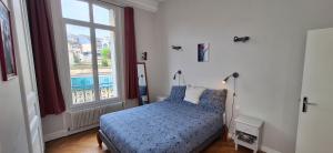 une chambre avec un lit et une grande fenêtre dans l'établissement St André Centre Rouen Standing, à Rouen