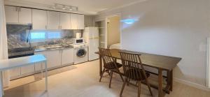 首尔Hongdae Yeondral Park, Z3, 7 minutes from Hongik Univ Station Exit 5, elevator ok的厨房配有桌子、两把椅子和冰箱