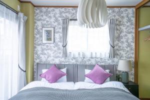 仓敷藤花Touka的卧室里有一张带紫色枕头的床