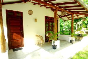 a house with a door and a chair and plants at Hiriketiya Don Simon Villa in Dickwella +99 photos