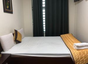 a bed in a room with a window at Khách sạn Sơn Hải in Ho Chi Minh City